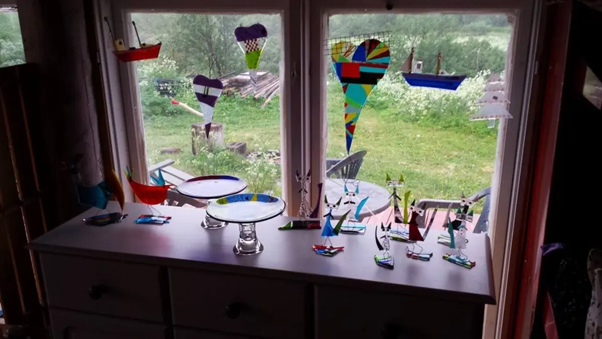 Fargerike glassfigurer i vinduskarmen