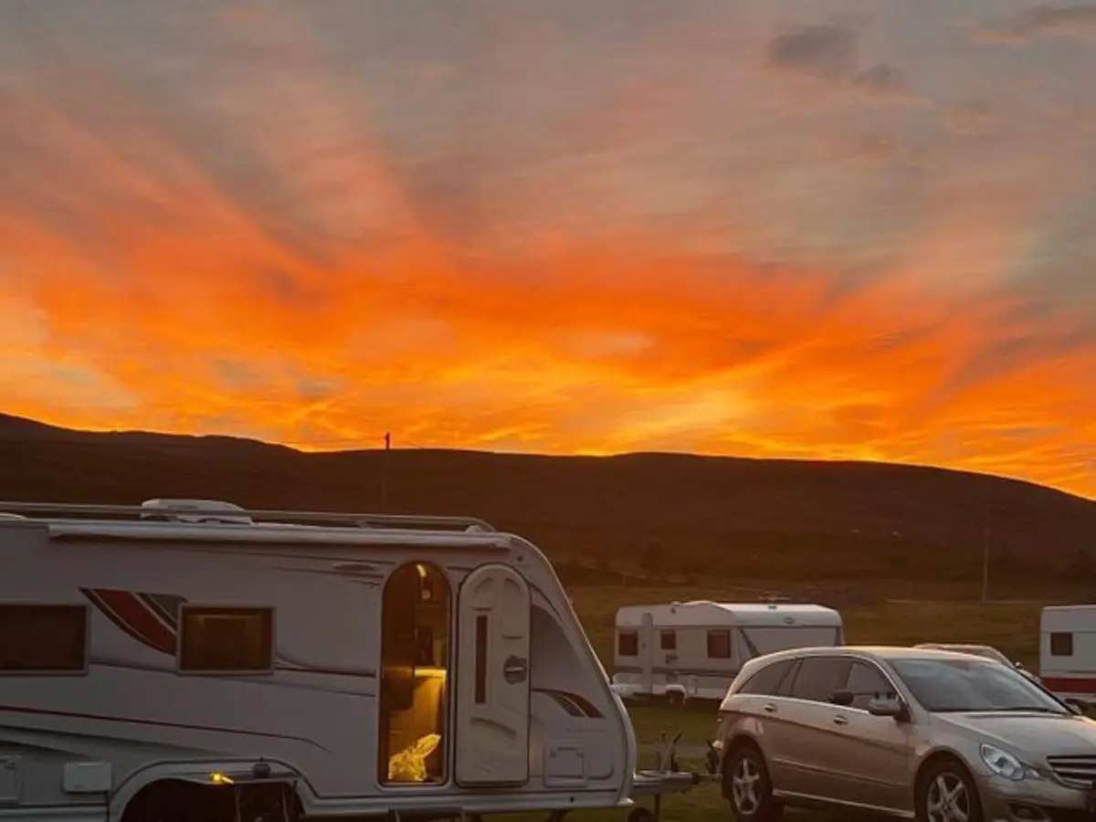 Solnedgang over campingplassen med bobil